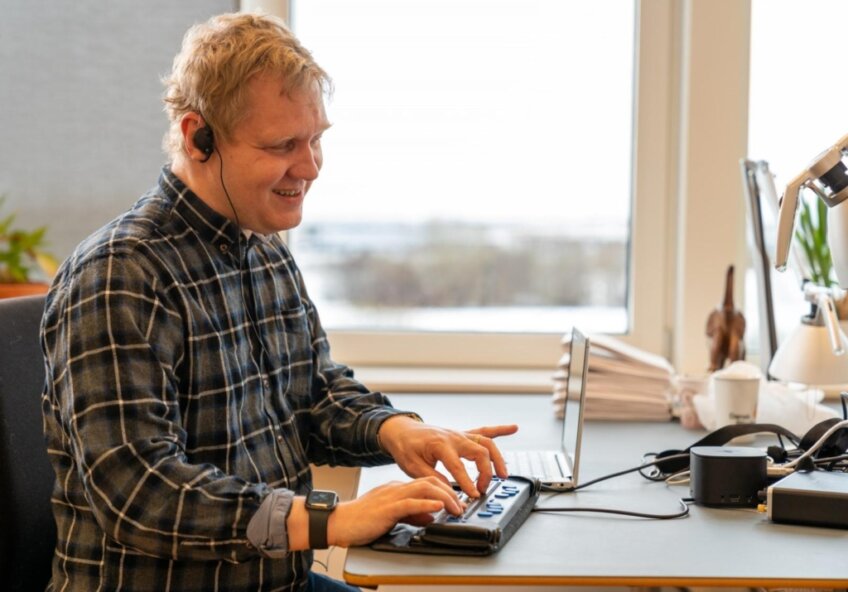 Et billede af en person, der interagerer med en hjemmeside ved hjælp af en skærmlæser, hvor hjemmesidens indhold er tydeligt struktureret og nemt at navigere.